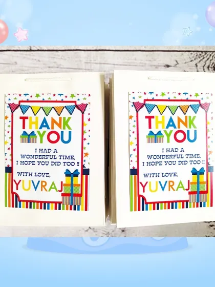 The custom paper bags for the stationery set gifts, featuring a colorful design and a thank you message from Yuvraj.