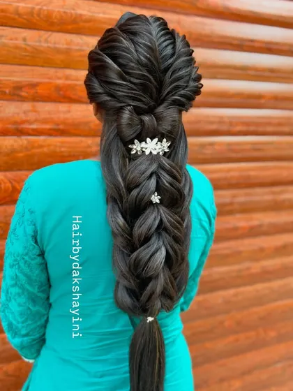 A beautiful and complex five-strand braid, adorned with delicate floral accessories. This is a popular choice for engagements and pre-wedding events.