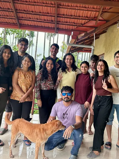 Our group relaxing at the homestay after the Bandaje trek, with a friendly local dog joining in for the photo.
