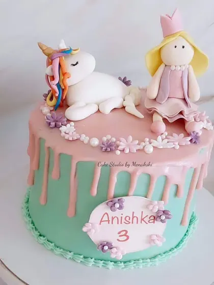 A sweet unicorn and princess cake for a 3rd birthday. This drip cake features hand-crafted figures and a lovely pink and teal color combination.