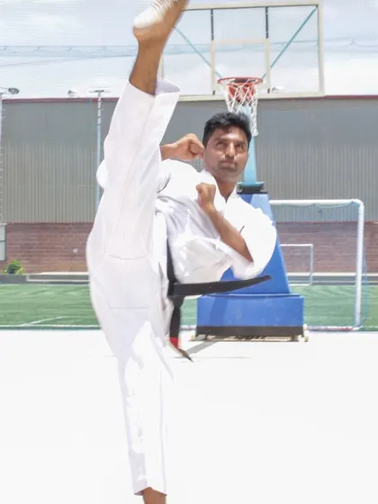 A demonstration of a high side kick (yoko geri), showing the flexibility and power required for advanced karate techniques.