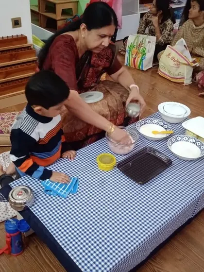 After the cooking is done, the cleanup begins. This child is learning to wipe the table, an essential part of the complete work cycle that teaches responsibility and care for the environment.
