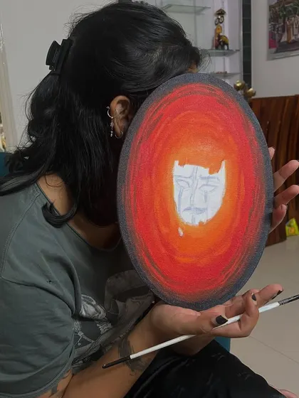 Here I am with a surrealist-style painting I created during an art date. It features a face emerging from a vibrant, fiery circular background.