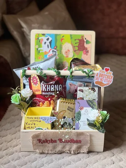 A playful Rakhi hamper for a younger brother, featuring a farm animal puzzle, snacks, and a cute panda notepad.