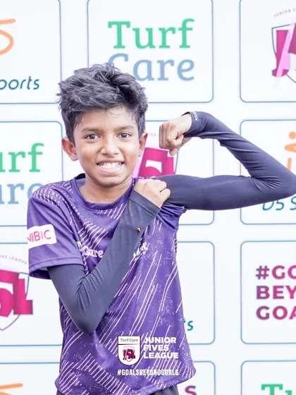A young player flexes, showing the strength and confidence gained through sport. I am dedicated to the holistic development of every athlete.
