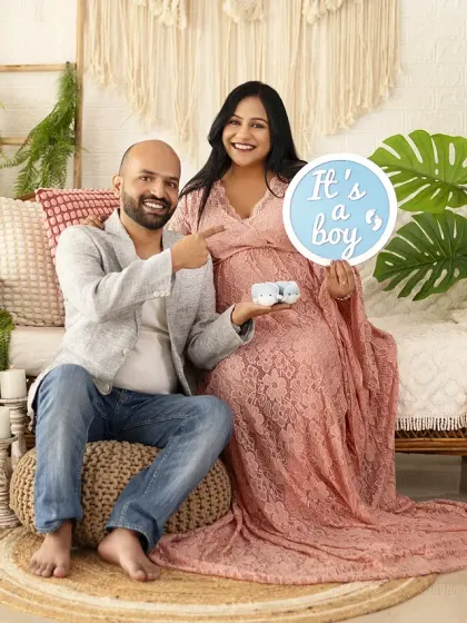 "It's a boy!" The dad-to-be proudly points to the sign in this happy announcement photo, celebrating the news with his partner.