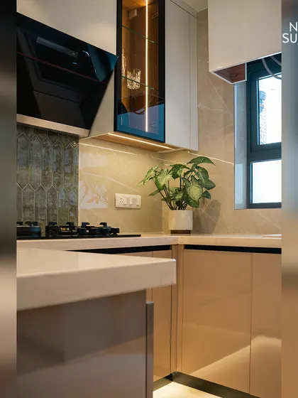 This corner of the renovated kitchen highlights the practical design, with ample counter space and well-placed power outlets. A potted plant adds a touch of green, bringing life to the minimalist design.