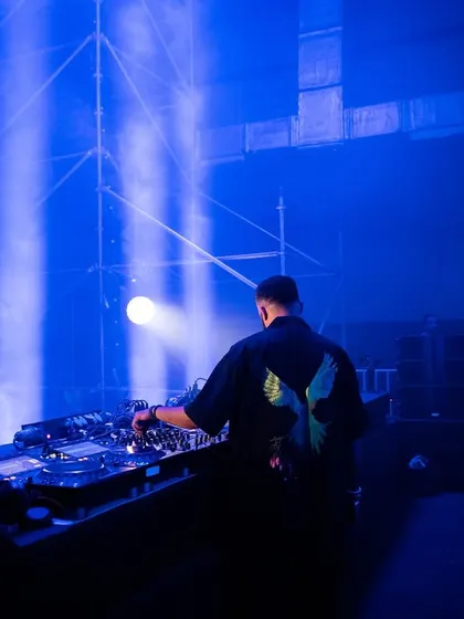 A shot from behind me on a massive stage, bathed in blue light. This captures the scale and atmosphere of a large indoor event.