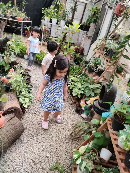 A child walks confidently down a gravel path at the nursery, fully immersed in the sensory experience of the visit.