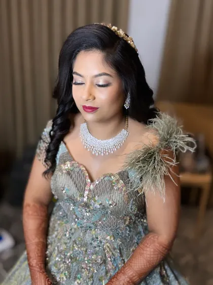 "Too glam to give a damn." This reception look for Bhavana features silver-toned shimmery eyes and a bold berry lip, perfect for her feathered gown.