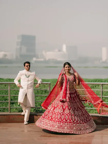 A stunning portrait of the couple against the Powai skyline. The bride's twirling red lehenga adds a beautiful sense of movement and grandeur to the shot.