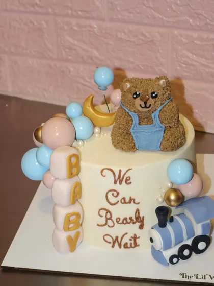 We can "bearly" handle the cuteness of this baby shower cake. It features a hand-sculpted teddy bear, pastel balloons, baby blocks, and a little toy train, all made from fondant and buttercream.