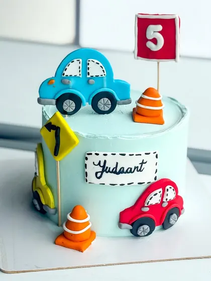 A bright and cheerful car-themed cake, perfect for a young child's birthday party.