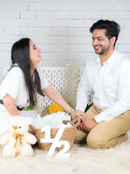 A candid moment of laughter between parents as they watch over their baby during a half-birthday photoshoot. It shows the joy and fun of our sessions.