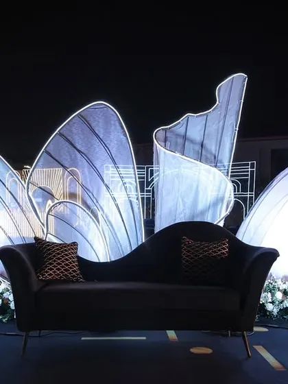 The main stage for the 'Neon Love' Sangeet, featuring a sculptural, illuminated backdrop that resembles glowing butterfly wings.