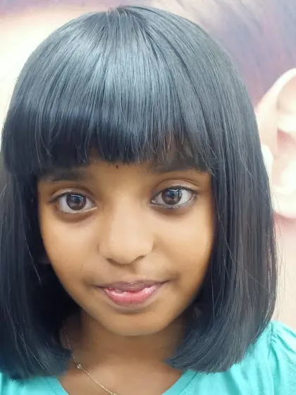 A classic bob with a full fringe for a young girl. This is a timeless and adorable haircut that is perfect for kids.