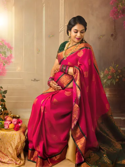 A quiet moment of reflection for a mother-to-be. Seated gracefully, she cradles her baby bump, surrounded by a soft, artistic setting that enhances her maternal glow.