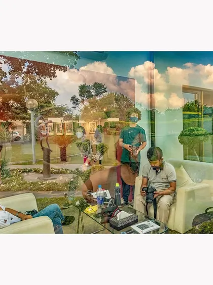 A complex reflection at a gallery in Delhi, merging the people inside with the sky and landscape outside. This photograph captures the life of the gallery, both within its walls and in the world reflected on its surface.