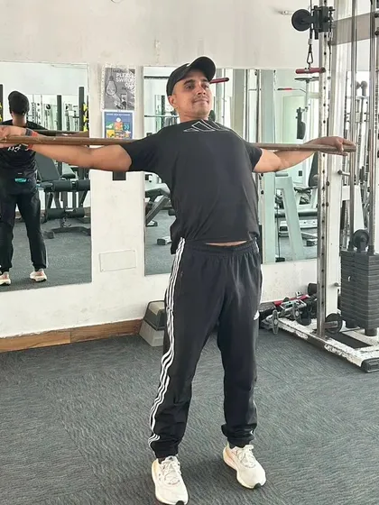 Completing a set of mobility exercises with a stick. Flexibility is just as important as strength.