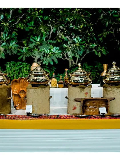 A rustic-themed buffet setup using earthen pots and traditional Indian serveware, perfect for events celebrating Indian heritage.