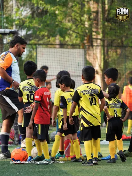 A coach gathers a group of young players for a quick talk. I believe clear communication and constant feedback are essential for development.