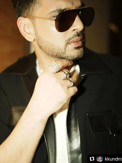 A detailed shot of Karan Kundrra's look, focusing on the accessories. The rings and chain add a layer of personality to the stylish jacket and sunglasses.