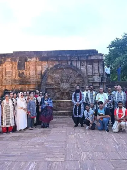 A group photo in front of the magnificent stone wheel of the Konark Sun Temple, a UNESCO World Heritage site. We explore these architectural marvels to absorb their ancient spiritual vibrations.