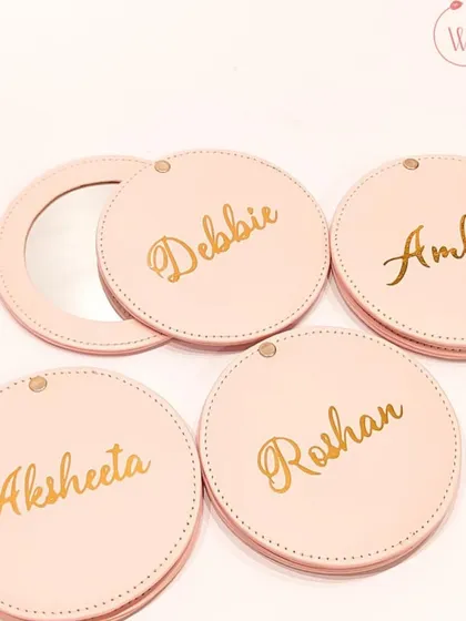 Personalized pocket mirrors with each guest's name in elegant gold script. A chic and personal favor that your guests can use every day.