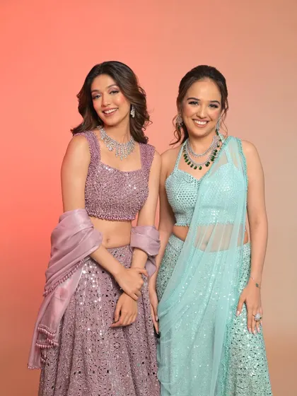 A lovely duo shot, showcasing two different party looks in pastel purple and blue, both featuring sparkling outfits and glamorous makeup.