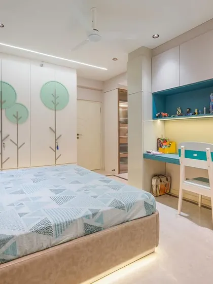Another view of the child's room, showing the integrated design of the bed, wardrobe, and study area. The consistent use of color and motifs creates a cohesive and joyful environment.