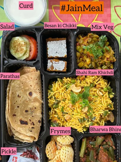 A detailed look inside one of my Jain meal thalis. This one features Shahi Ram Khichdi, Mix Veg, Bharwa Bhindi, Parathas, Salad, Curd, and even a sweet Besan ki Chikki.