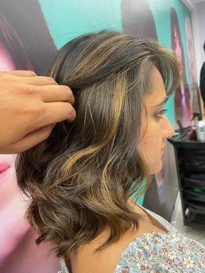 Balayage works beautifully on shorter, bob-length hair too. These subtle, warm highlights add dimension and the illusion of volume to this wavy lob haircut.