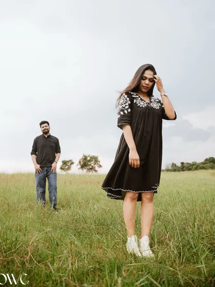 A beautifully composed shot with the couple positioned apart in a field, creating a sense of longing and connection across the distance.