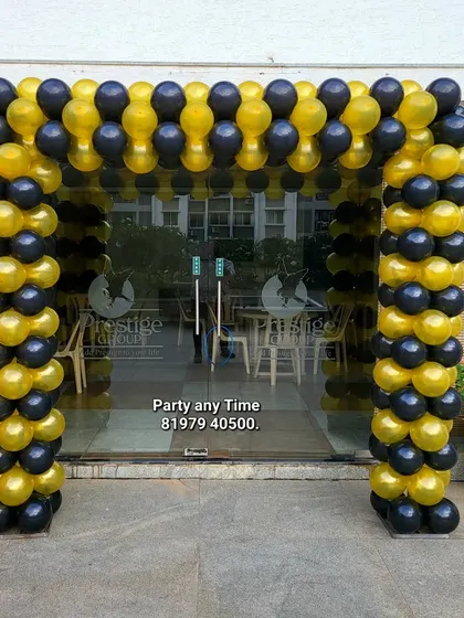 A balloon arch in black and yellow, perfect for an entrance decoration for a corporate event or store opening.