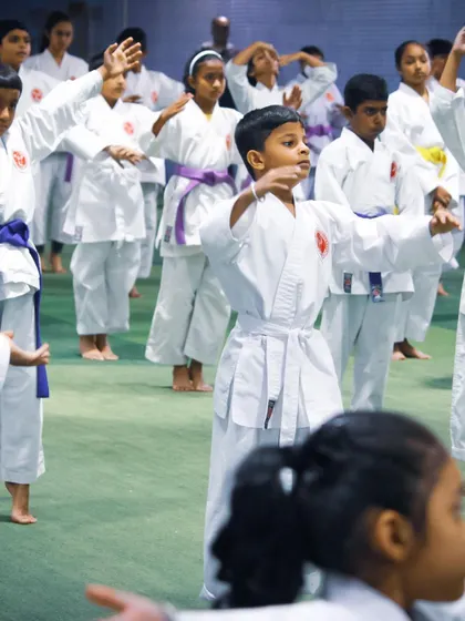 A group of young boys and girls practice their blocking techniques, learning essential self-defense skills in a structured environment.