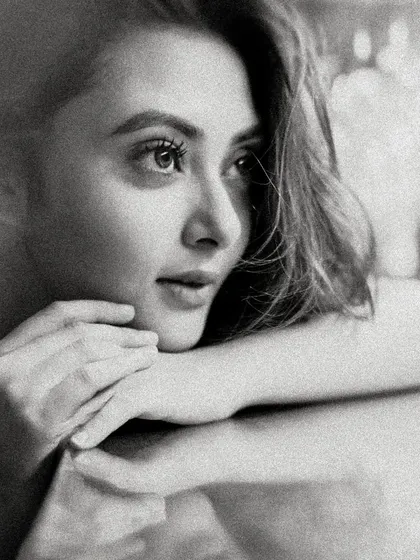 The same portrait of Megha Chowdhury in black and white. The monochrome treatment adds a layer of classic elegance and focuses entirely on her expression and the beautiful lighting.
