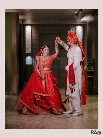 A playful and romantic shot of the groom twirling his bride in a beautifully lit corridor on their wedding day.