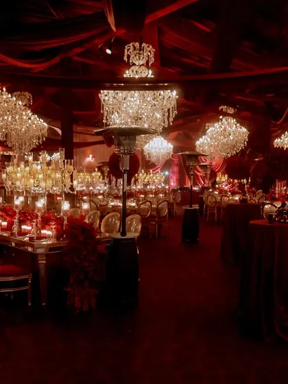 The entire event space was a vision in red, with massive crystal chandeliers hanging from a ceiling of draped fabric. The consistent color scheme and lighting created a powerful, immersive experience.
