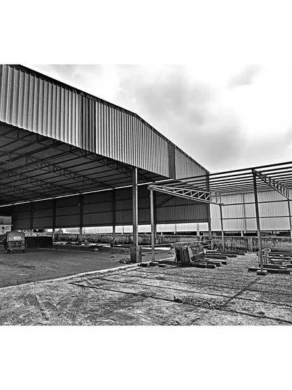The steel structural framework of the warehouse during the construction phase. This image shows the scale of the industrial building and the engineering that forms its foundation, a key part of our end-to-end architectural services.