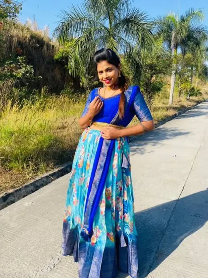 A client posing outdoors in a blue floral printed Langa Davani, a fresh and modern choice for a daytime event.