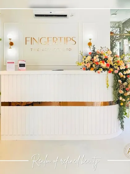 The reception desk at Fingertips Nail Studio sets the tone for the entire space. I designed it with clean white lines, a touch of gold trim, and elegant wall sconces to create a minimalist yet welcoming first impression. The fresh flowers add a soft, natural element to the refined design.
