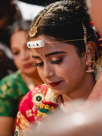 A close-up candid from a wedding ceremony. This shot captures the emotion of the moment, with the bride's makeup looking flawless and beautiful.