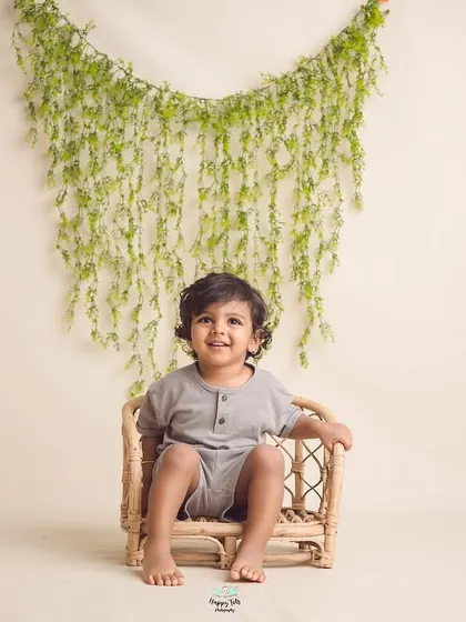 This handsome boy's sweet smile is the only thing that matters here. We use simple, neutral sets to let your child's natural charm shine.