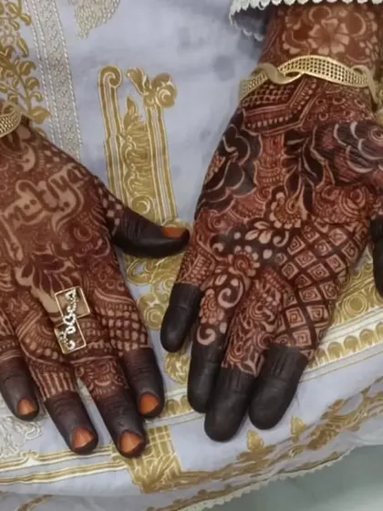 A candid shot of the party mehendi, showing how it complements the client's beautiful outfit and jewelry.