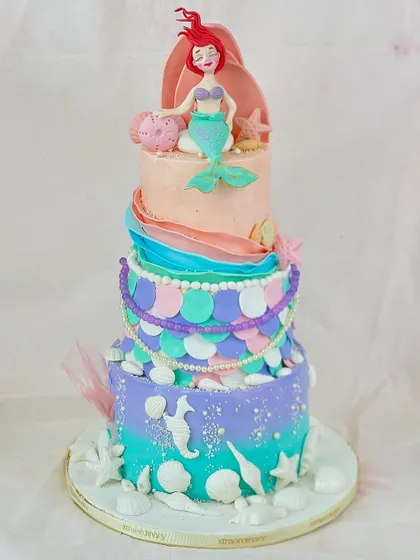 Let's go under the sea! This multi-tiered mermaid cake is a deep-sea dream, with colorful scales, seashell details, and a beautifully sculpted Ariel on top.