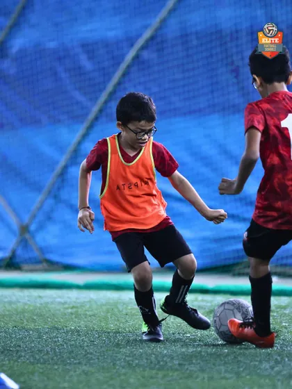 Focus and control. A young player shields the ball during a training drill. We teach ball mastery and game awareness from the earliest age.