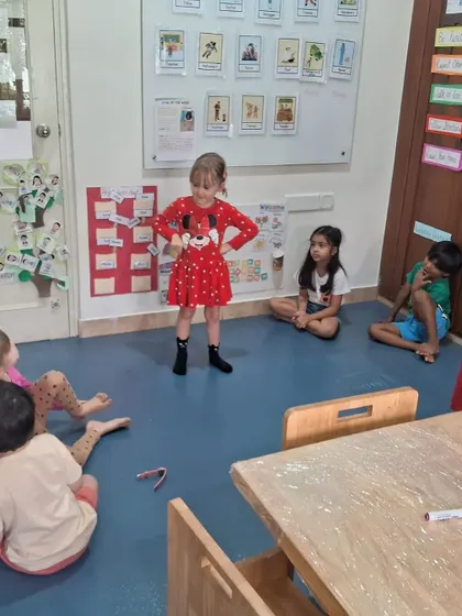 A child presents her work to the class after the petrol pump visit, demonstrating her understanding of the experience.