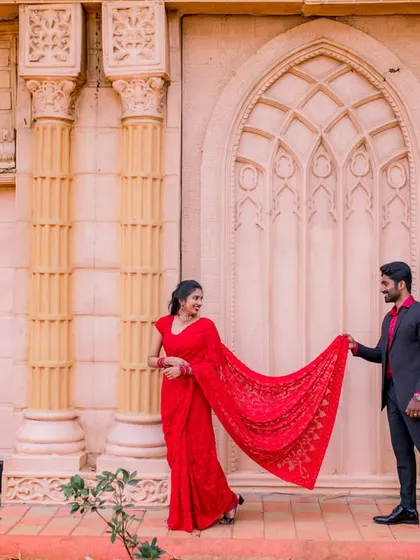 A playful and romantic moment with the bride's saree. This shot is full of movement and captures the couple's fun-loving connection.