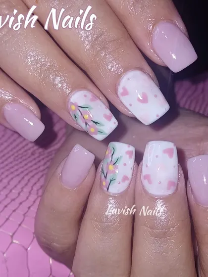 A sweet and delicate design featuring a soft pink base with accent nails hand-painted with tiny hearts and a floral vine.