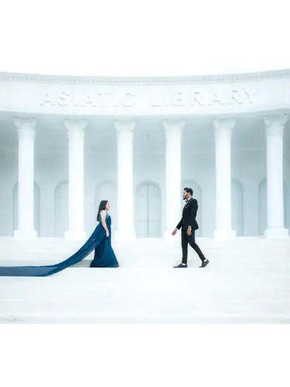 A wide, symmetrical shot of the couple on the steps of the studio set, creating a powerful and cinematic feel.